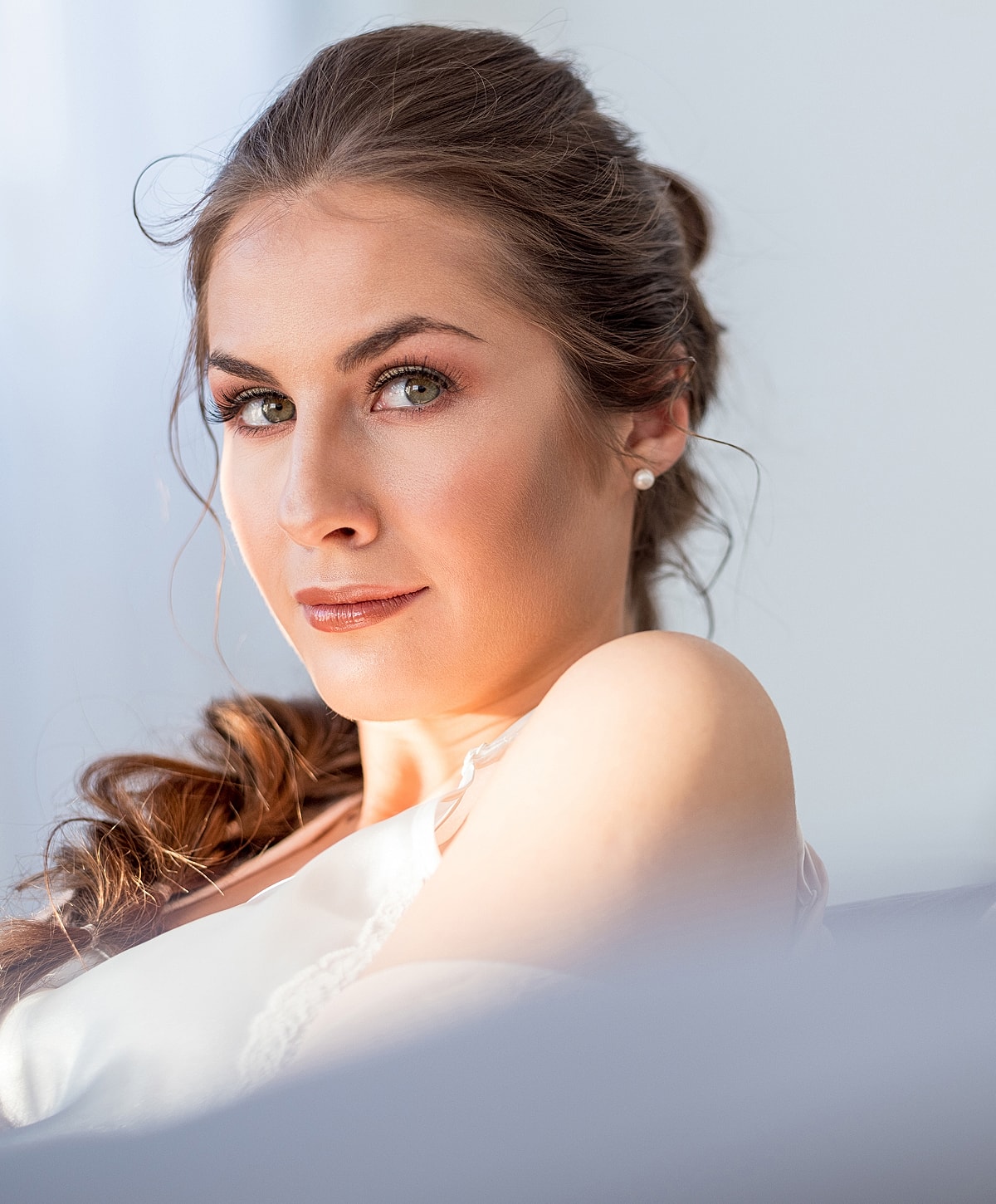 Woman with elegant hair and makeup, soft lighting.