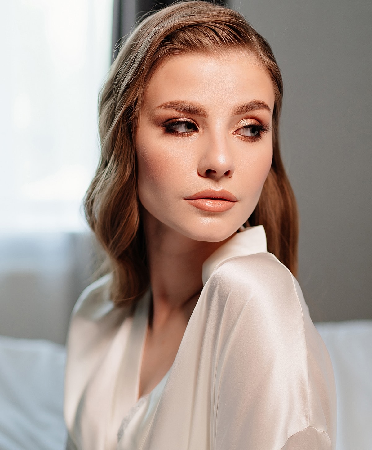 Woman with soft makeup and silky robe.
