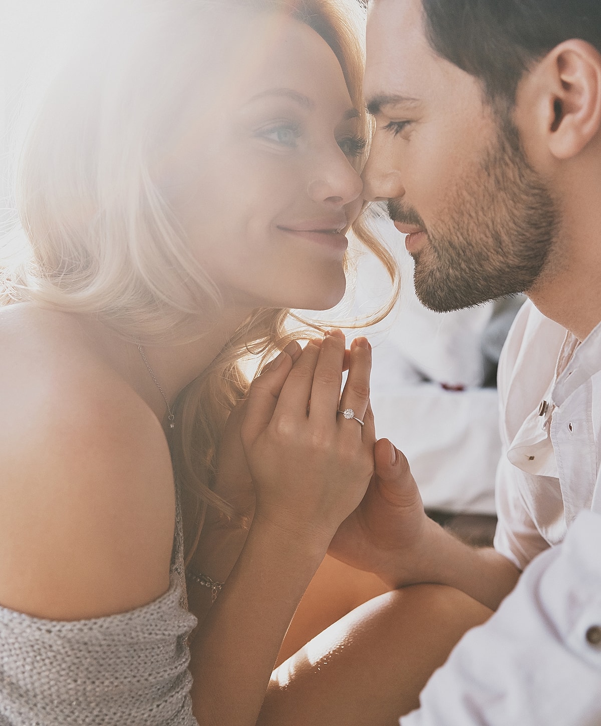 Couple sharing a tender moment with engagement ring.