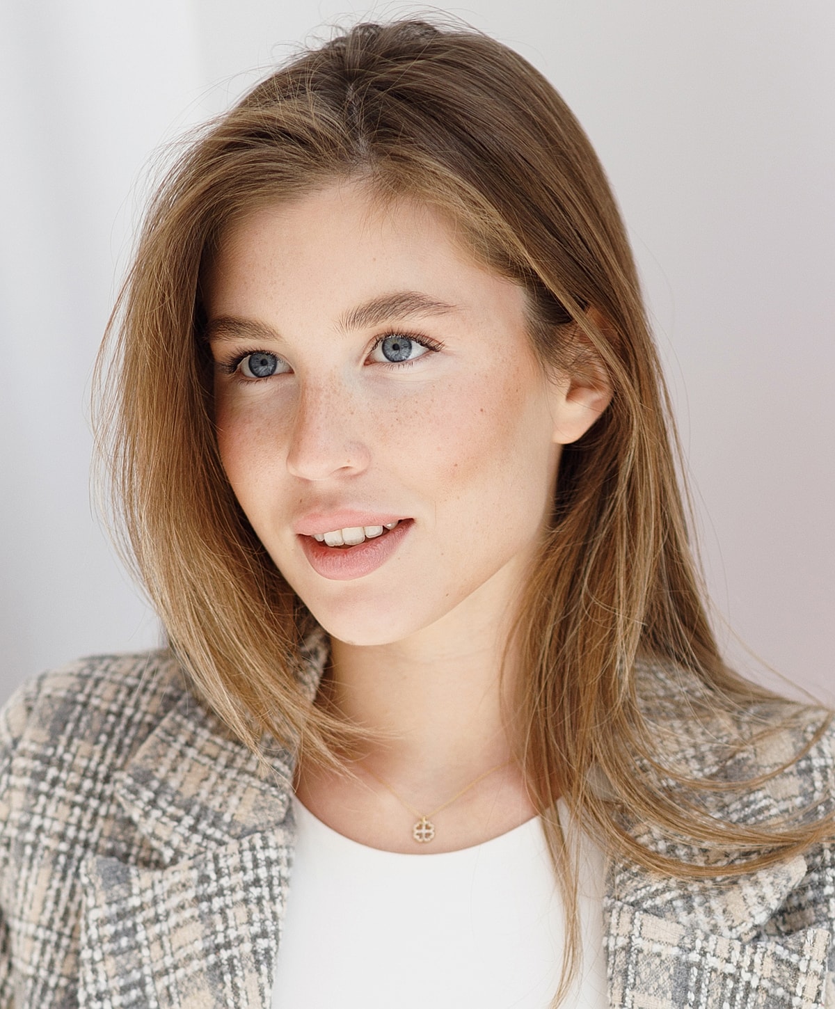 Smiling young woman with blue eyes and freckles.