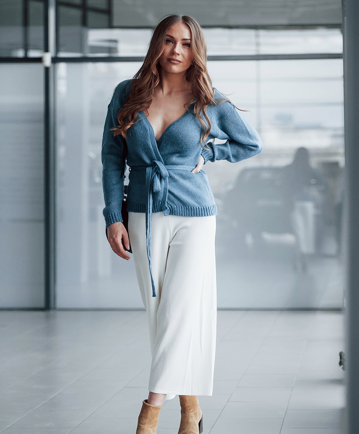 Model in stylish blue sweater and white pants