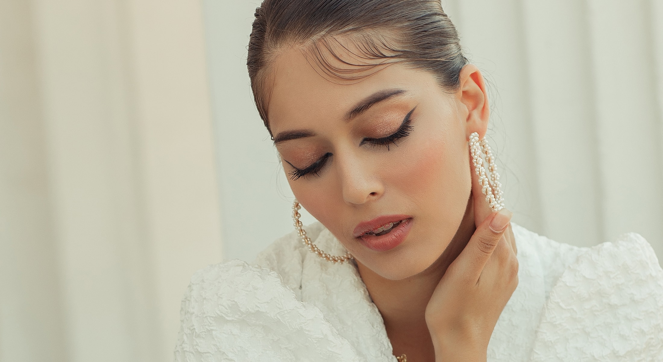 Woman contemplating with elegant accessories and makeup.